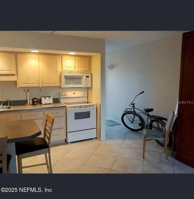 3700 Atlantic Ave Unit 405, New Smyrna Beach, FL 32169 - kitchen featuring white appliances, light tile patterned flooring, and light countertops