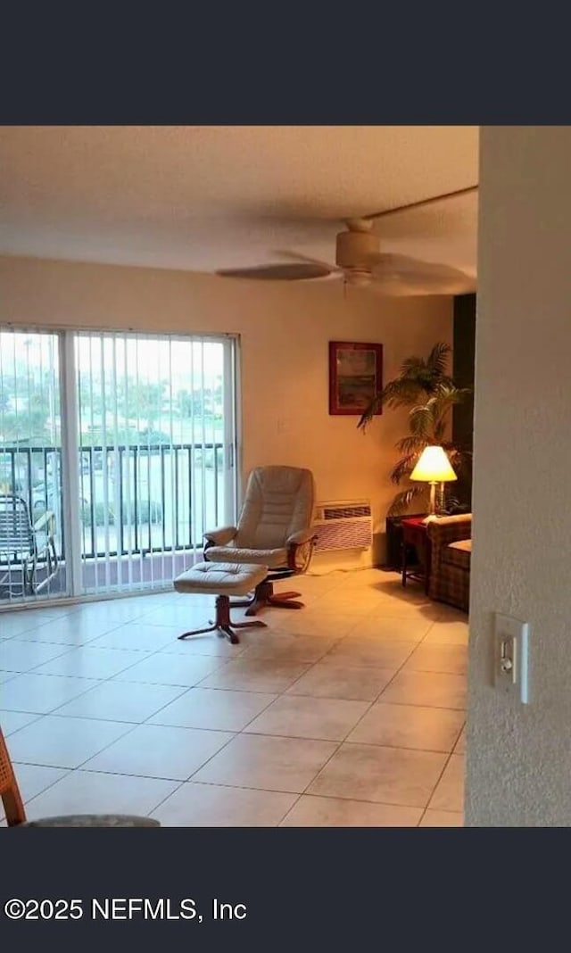 3700 Atlantic Ave Unit 405, New Smyrna Beach, FL 32169 - living room featuring tile patterned floors, ceiling fan, and a wall mounted air conditioner