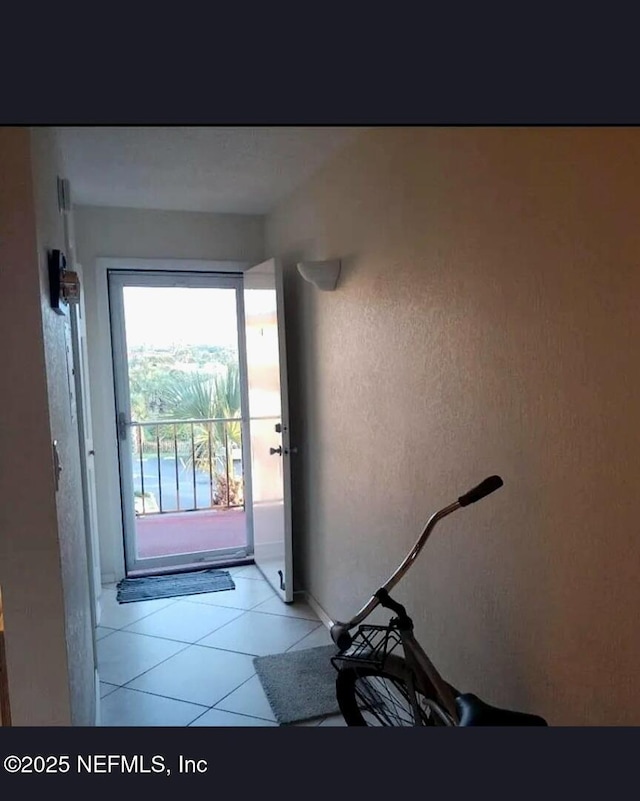 3700 Atlantic Ave Unit 405, New Smyrna Beach, FL 32169 - doorway to outside with light tile patterned flooring and baseboards