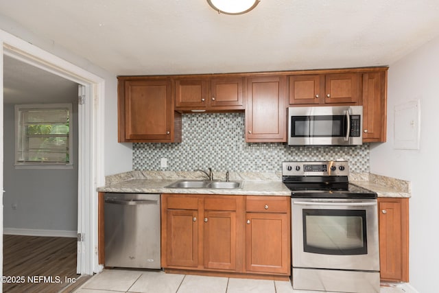 3303 Jones St, Jacksonville, FL 32206 - kitchen featuring appliances with stainless steel finishes, tasteful backsplash, and brown cabinetry