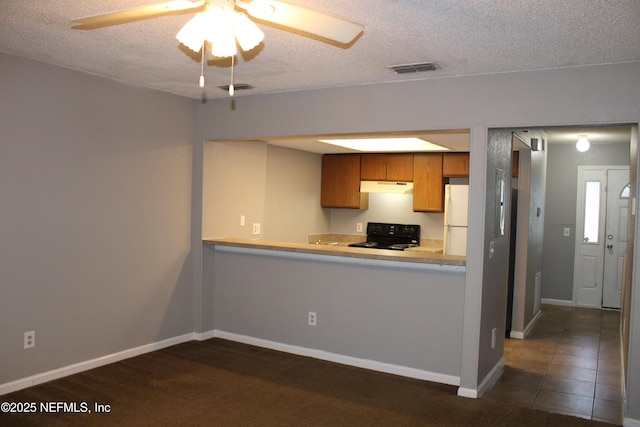 791 Assisi Ln Unit 302, Jacksonville, FL 32233 - kitchen featuring stove, freestanding refrigerator, a textured ceiling, under cabinet range hood, and brown cabinetry
