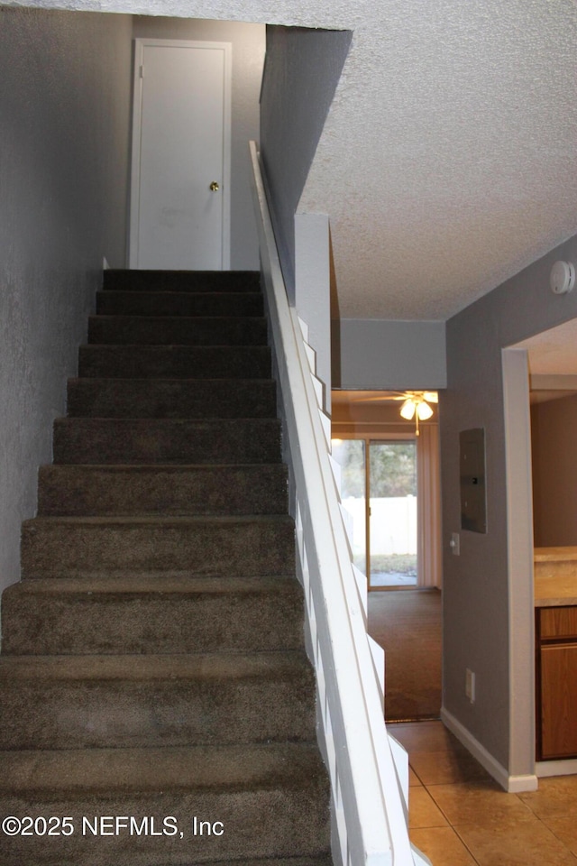 791 Assisi Ln Unit 302, Jacksonville, FL 32233 - stairway featuring tile patterned floors, a textured ceiling, and electric panel