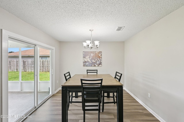 96016 Gray Heron Ct, Yulee, FL 32097 - dining room featuring a chandelier, wood finished floors, and a textured ceiling