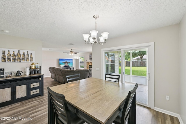 96016 Gray Heron Ct, Yulee, FL 32097 - dining space with a chandelier, dark wood-type flooring, a textured ceiling, and ceiling fan