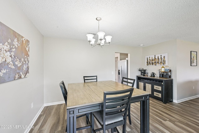 96016 Gray Heron Ct, Yulee, FL 32097 - dining room featuring wood finished floors, a chandelier, and a textured ceiling