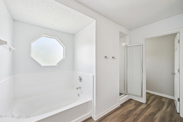 96016 Gray Heron Ct, Yulee, FL 32097 - bathroom with wood finished floors, a garden tub, a textured ceiling, and a shower stall