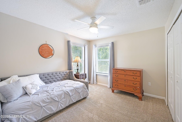 96016 Gray Heron Ct, Yulee, FL 32097 - bedroom with a closet, light carpet, a textured ceiling, and a ceiling fan