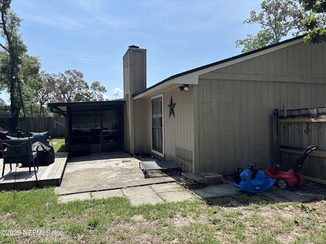 3112 Hampstead Dr, Jacksonville, FL 32225 - rear view of property featuring a chimney, a wooden deck, and a sunroom