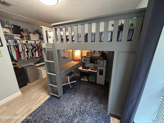3112 Hampstead Dr, Jacksonville, FL 32225 - bedroom with wood finished floors, a closet, and a textured ceiling