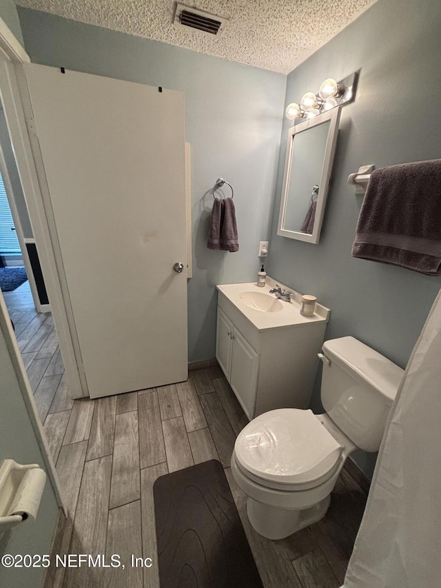 3112 Hampstead Dr, Jacksonville, FL 32225 - bathroom with wood tiled floors, a textured ceiling, and vanity