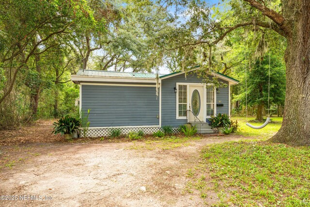 610 Division St, Fernandina Beach, FL 32034 - view of front of property with entry steps and a metal roof