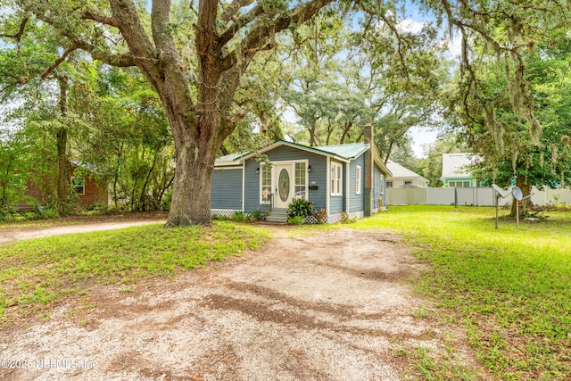 610 Division St, Fernandina Beach, FL 32034 - view of front of house with a chimney, dirt driveway, and entry steps