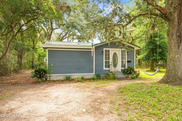 610 Division St, Fernandina Beach, FL 32034 - view of front facade featuring entry steps and a metal roof