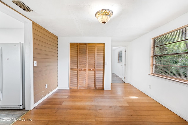 610 Division St, Fernandina Beach, FL 32034 - unfurnished bedroom with freestanding refrigerator, light wood-style flooring, and a closet