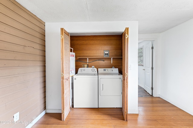 610 Division St, Fernandina Beach, FL 32034 - laundry area with washer and dryer, light wood-style flooring, wooden walls, and a textured ceiling
