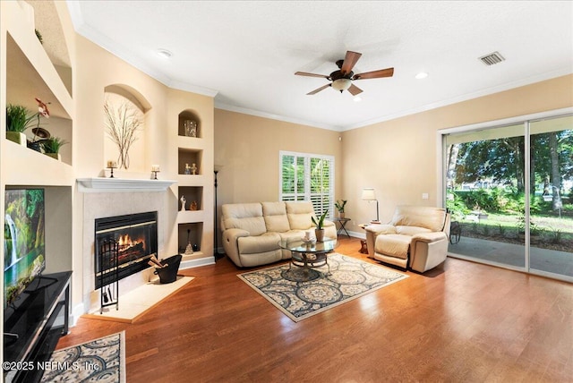 85339 Amagansett Dr, Fernandina Beach, FL 32034 - living area with wood finished floors, built in features, ceiling fan, a fireplace, and ornamental molding