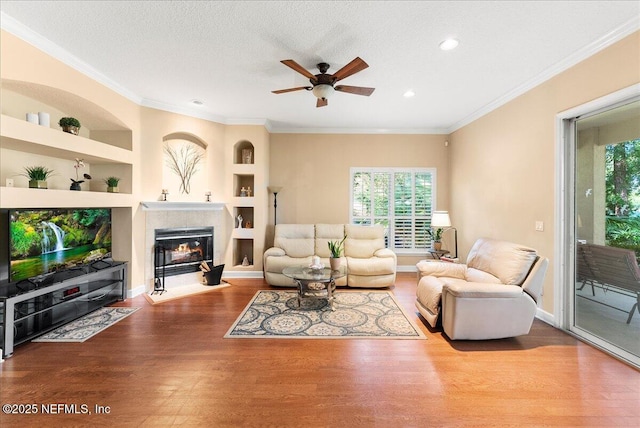85339 Amagansett Dr, Fernandina Beach, FL 32034 - living area featuring built in shelves, healthy amount of natural light, a fireplace with flush hearth, wood finished floors, and recessed lighting