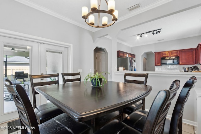 86051 Venetian Ave, Yulee, FL 32097 - dining room with arched walkways, a chandelier, crown molding, and rail lighting