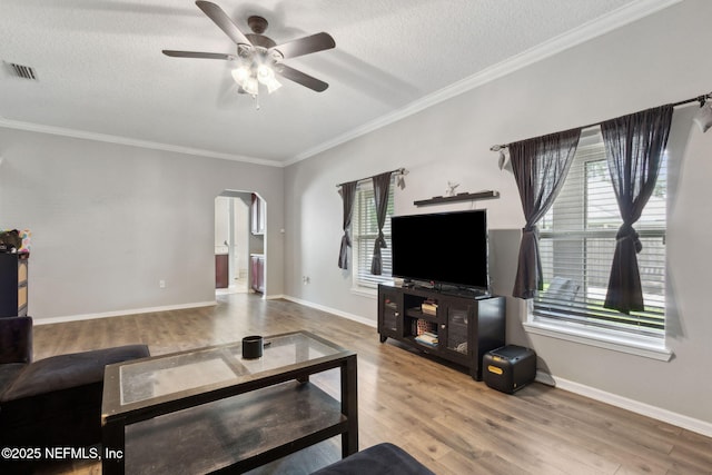86051 Venetian Ave, Yulee, FL 32097 - living area featuring arched walkways, a ceiling fan, wood finished floors, plenty of natural light, and ornamental molding