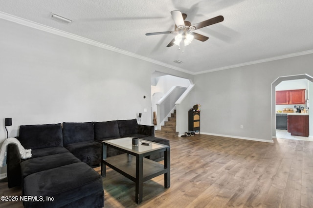 86051 Venetian Ave, Yulee, FL 32097 - living room with ceiling fan, light wood-style floors, a textured ceiling, arched walkways, and stairs