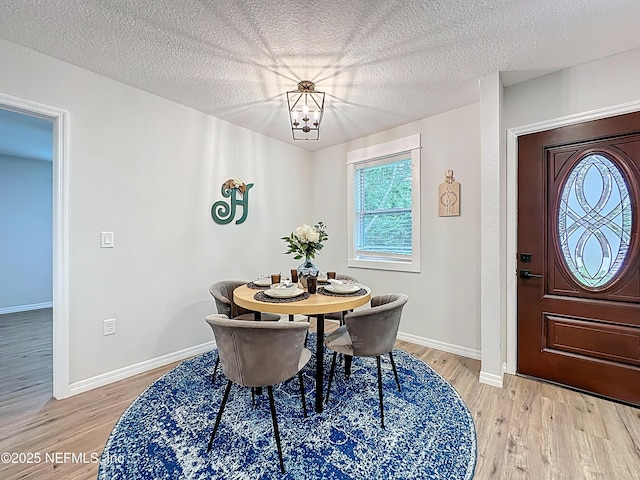 540485 US Highway 1, Callahan, FL 32011 - dining space featuring light wood-style floors, a chandelier, and a textured ceiling