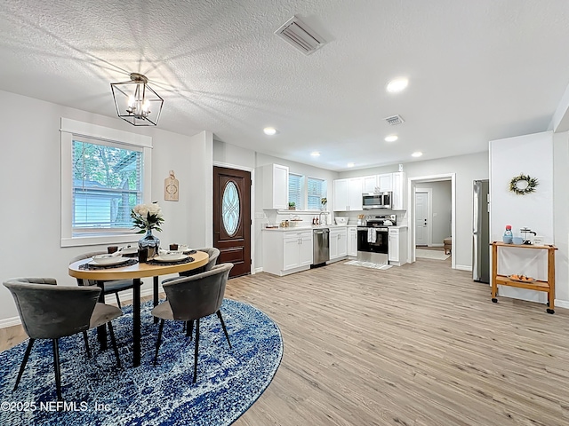 540485 US Highway 1, Callahan, FL 32011 - dining space with light wood-style floors, plenty of natural light, a chandelier, recessed lighting, and a textured ceiling