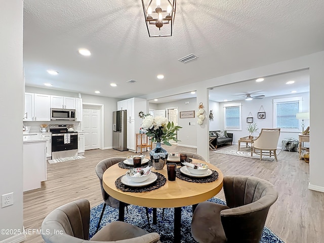 540485 US Highway 1, Callahan, FL 32011 - dining area featuring light wood-style flooring, a ceiling fan, a textured ceiling, recessed lighting, and a chandelier