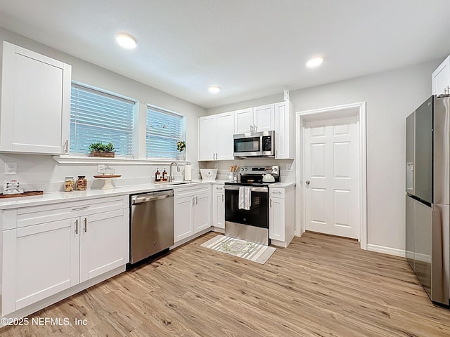 540485 US Highway 1, Callahan, FL 32011 - kitchen featuring stainless steel appliances, white cabinets, light wood-style flooring, light countertops, and recessed lighting