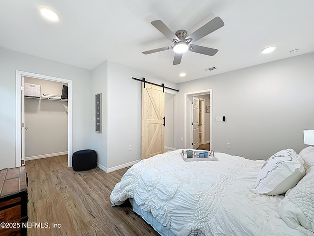 540485 US Highway 1, Callahan, FL 32011 - bedroom featuring a barn door, wood finished floors, recessed lighting, a ceiling fan, and a spacious closet