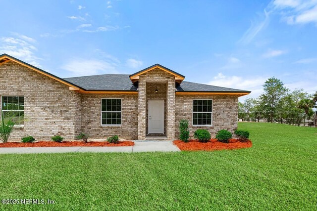 451632 Old Dixie Hwy, Callahan, FL 32011 - view of front of property featuring a front lawn, roof with shingles, and brick siding