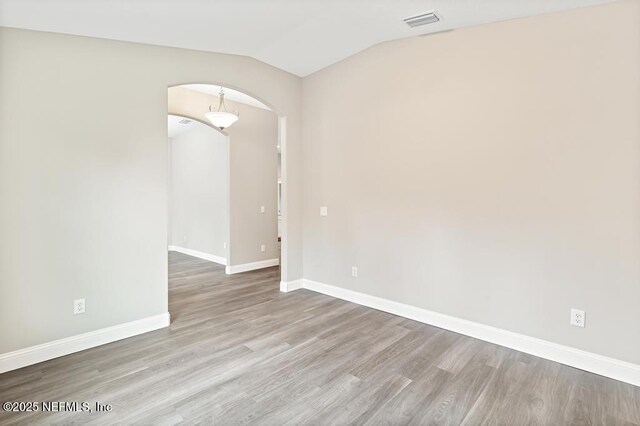 451632 Old Dixie Hwy, Callahan, FL 32011 - unfurnished room featuring arched walkways, lofted ceiling, and wood finished floors