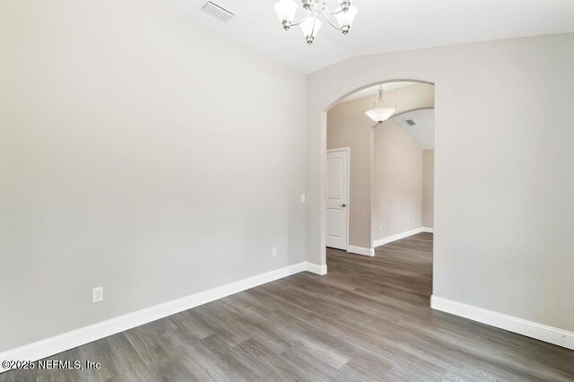451632 Old Dixie Hwy, Callahan, FL 32011 - empty room with arched walkways, vaulted ceiling, a chandelier, and wood finished floors