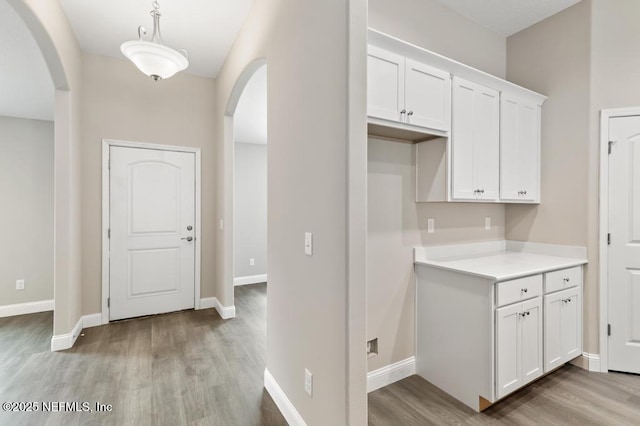 451632 Old Dixie Hwy, Callahan, FL 32011 - kitchen featuring arched walkways, white cabinetry, light wood-style floors, and light countertops