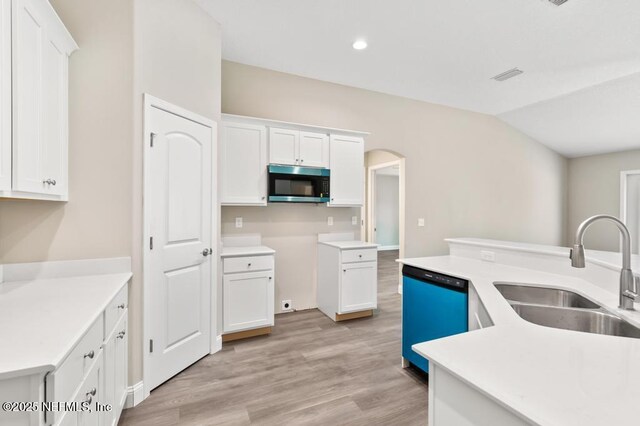 451632 Old Dixie Hwy, Callahan, FL 32011 - kitchen featuring stainless steel microwave, dishwasher, arched walkways, white cabinetry, and light wood-type flooring