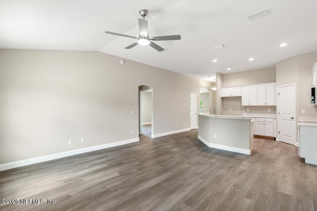 451632 Old Dixie Hwy, Callahan, FL 32011 - kitchen featuring arched walkways, a center island with sink, a ceiling fan, open floor plan, and wood finished floors