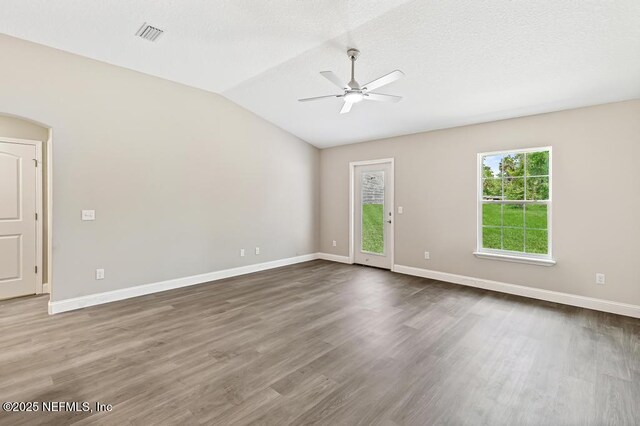 451632 Old Dixie Hwy, Callahan, FL 32011 - spare room with ceiling fan, dark wood-style flooring, lofted ceiling, a textured ceiling, and arched walkways