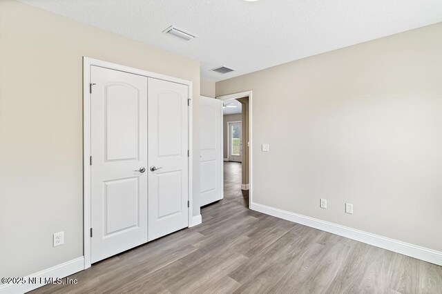 451632 Old Dixie Hwy, Callahan, FL 32011 - unfurnished bedroom featuring light wood-type flooring and a closet