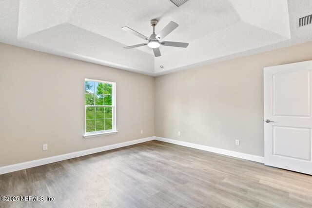 451632 Old Dixie Hwy, Callahan, FL 32011 - empty room with a tray ceiling, wood finished floors, ceiling fan, and a textured ceiling
