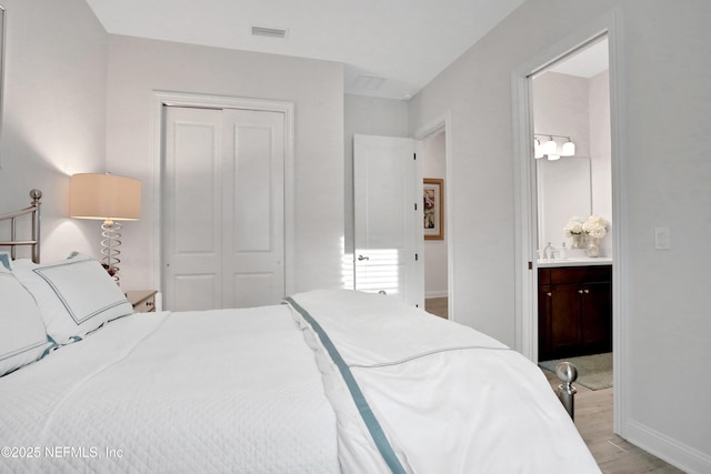 2459 Karatas Ct, Jacksonville, FL 32246 - bedroom with a closet, ensuite bathroom, and light wood-style flooring