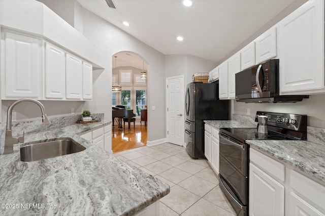 1630 Highland View Ct, Fleming Island, FL 32003 - kitchen with black appliances, arched walkways, light stone countertops, white cabinets, and recessed lighting