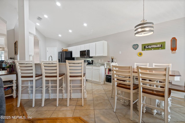 1630 Highland View Ct, Fleming Island, FL 32003 - dining space with lofted ceiling, recessed lighting, arched walkways, a chandelier, and light tile patterned floors