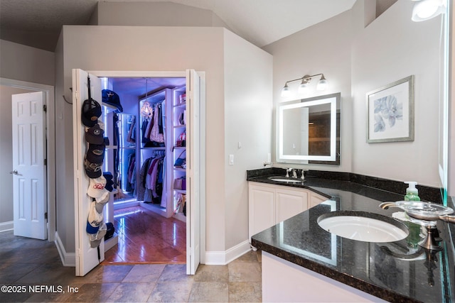 1630 Highland View Ct, Fleming Island, FL 32003 - bathroom featuring vanity, stone finish floors, and a walk in closet