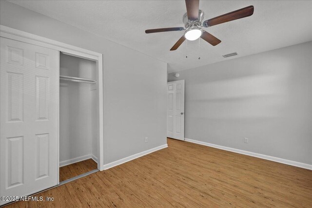 1622 Roselle Ave, Palatka, FL 32177 - unfurnished bedroom featuring wood finished floors, a closet, and ceiling fan