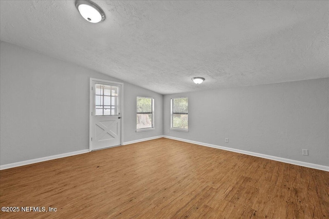 1622 Roselle Ave, Palatka, FL 32177 - empty room with a textured ceiling, wood finished floors, and vaulted ceiling