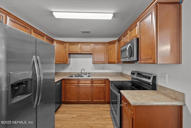 1622 Roselle Ave, Palatka, FL 32177 - kitchen featuring appliances with stainless steel finishes, brown cabinets, light wood-style floors, and light countertops
