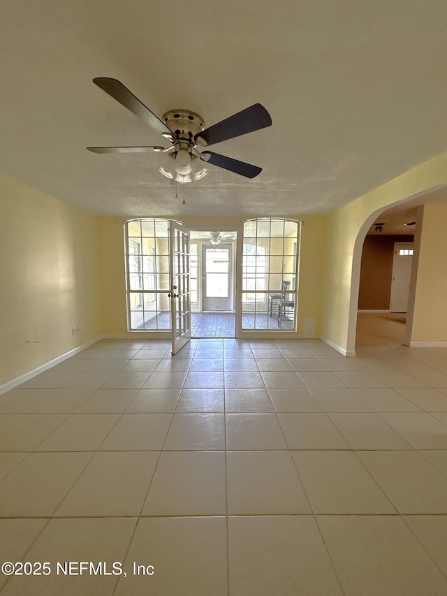 2590 Eastill Dr, Jacksonville, FL 32211 - spare room with light tile patterned floors, arched walkways, ceiling fan, and french doors
