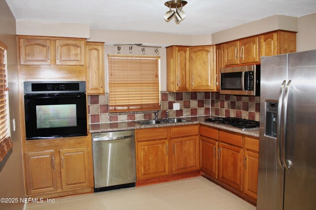 2590 Eastill Dr, Jacksonville, FL 32211 - kitchen with stainless steel appliances, tasteful backsplash, and brown cabinetry