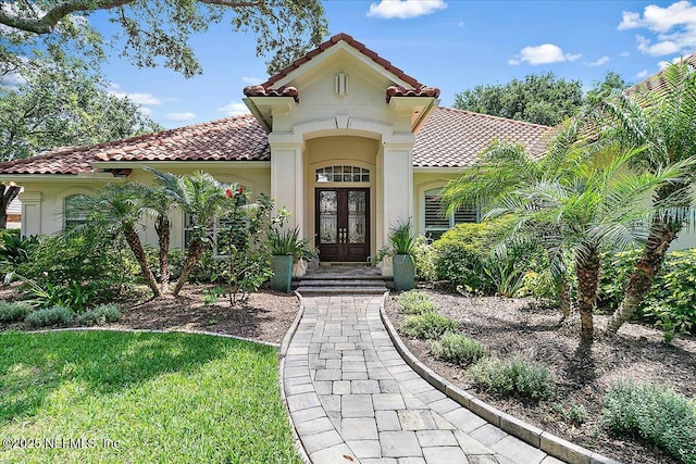 104 Haverhill Dr, Ponte Vedra Beach, FL 32082 - view of exterior entry with french doors, a tiled roof, and stucco siding
