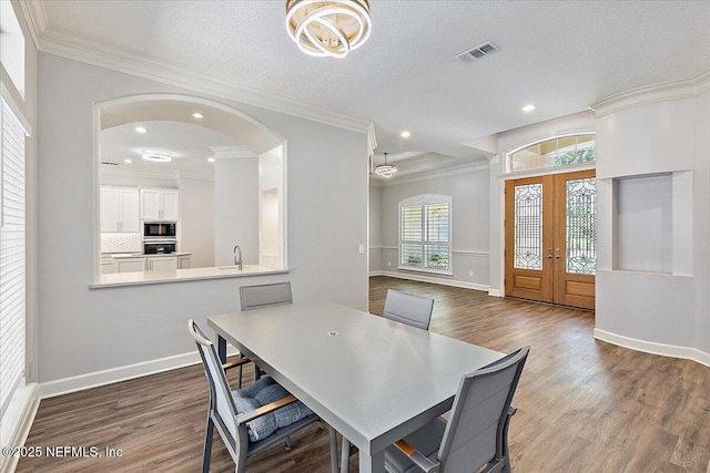 104 Haverhill Dr, Ponte Vedra Beach, FL 32082 - dining room featuring french doors, arched walkways, crown molding, dark wood-style floors, and recessed lighting