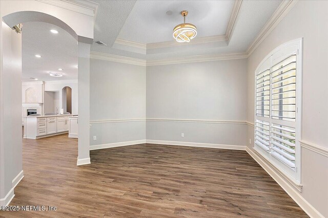 104 Haverhill Dr, Ponte Vedra Beach, FL 32082 - empty room with arched walkways, wood finished floors, crown molding, recessed lighting, and a tray ceiling